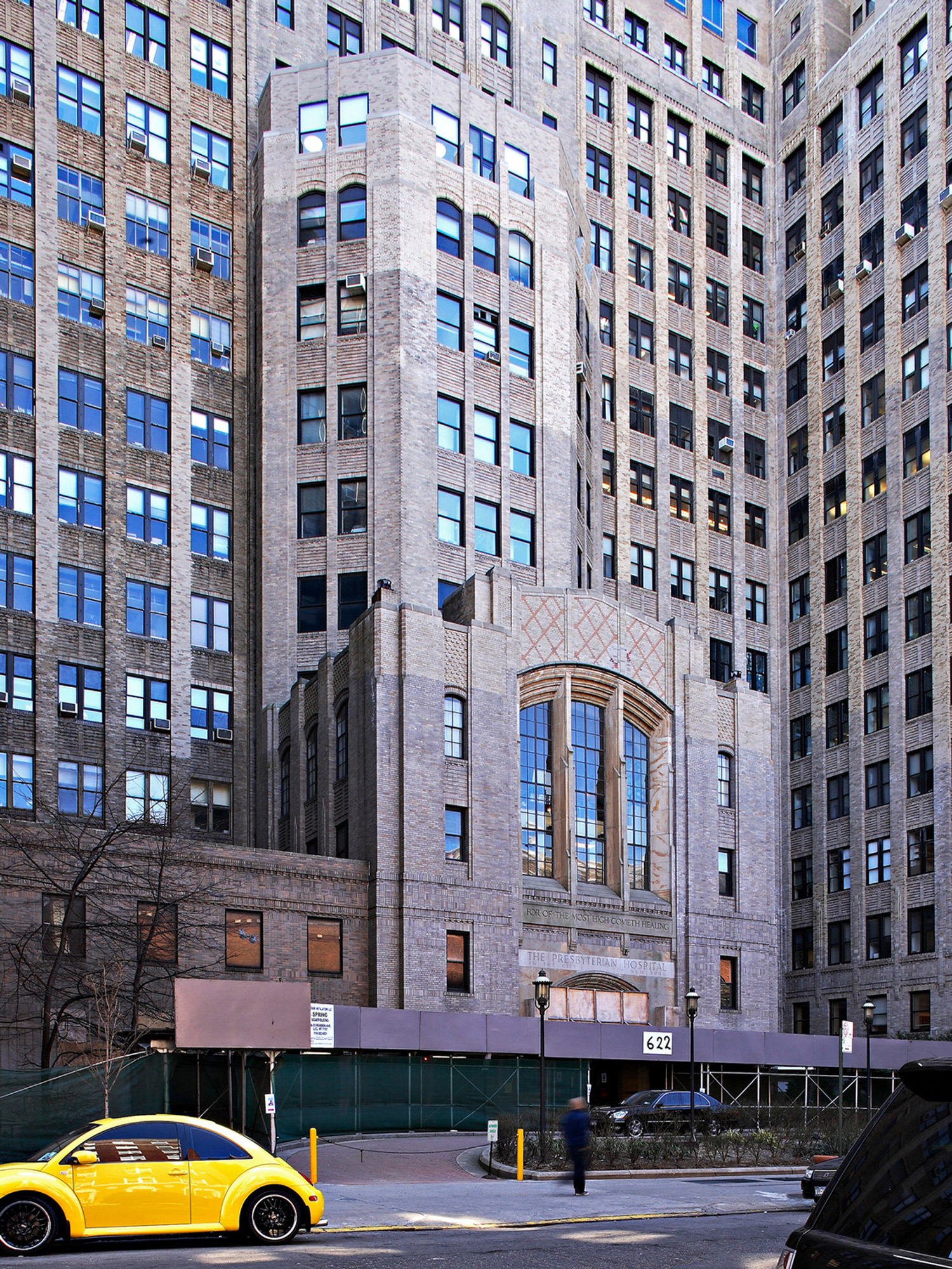Art Deco skyscraper with vertical lines and geometric accents, emphasizing the 1920s architectural style. The facade showcases intricate stonework and tall windows with ornate detailing around the entryway.