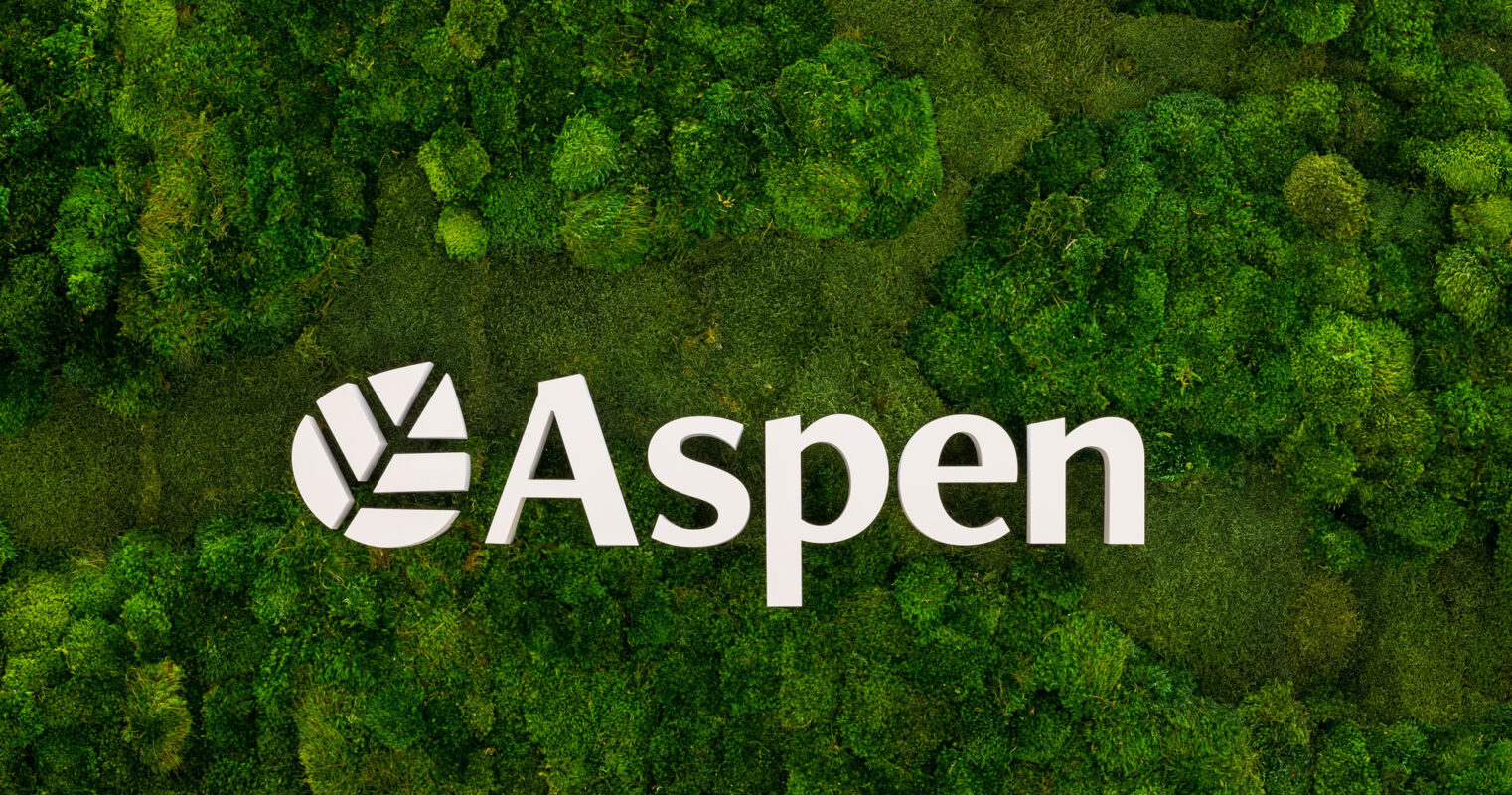 Lush greenery envelopes the Aspen logo, symbolizing eco-friendly design with a seamless blend of nature and branding, ideal for biophilic interior concepts.