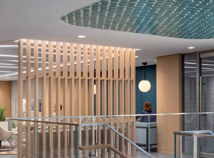 Modern office lobby featuring a natural wood slat partition, a wavy blue ceiling design, sleek glass railings, and minimalist furniture, illuminated by soft, ambient lighting.