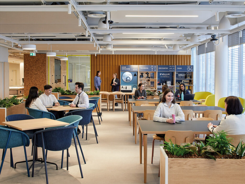 Open cafe and informal collaboration space with warm interior finishes and biophilic design.