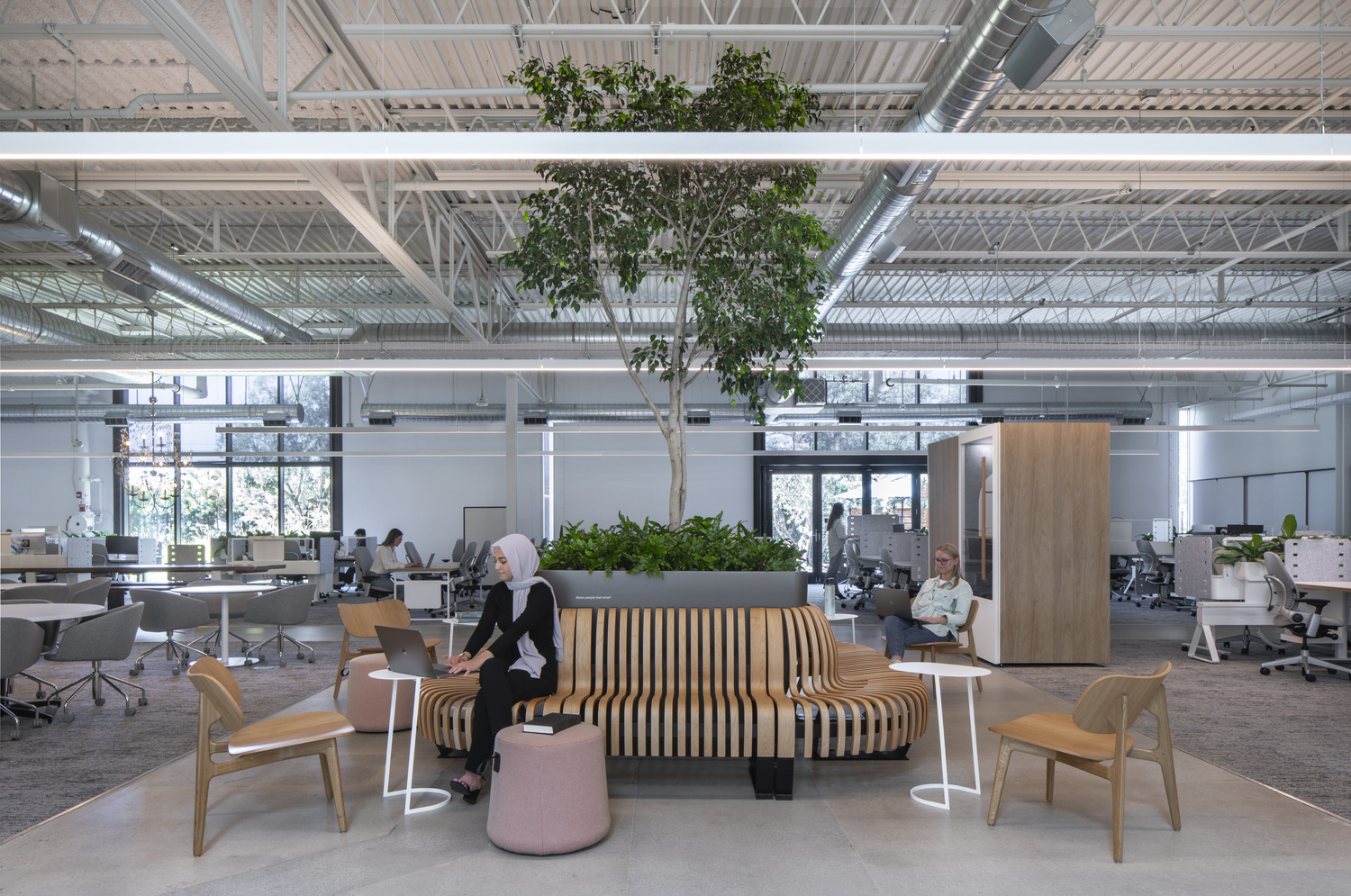 Modern office space with employees at work and casual seating areas.