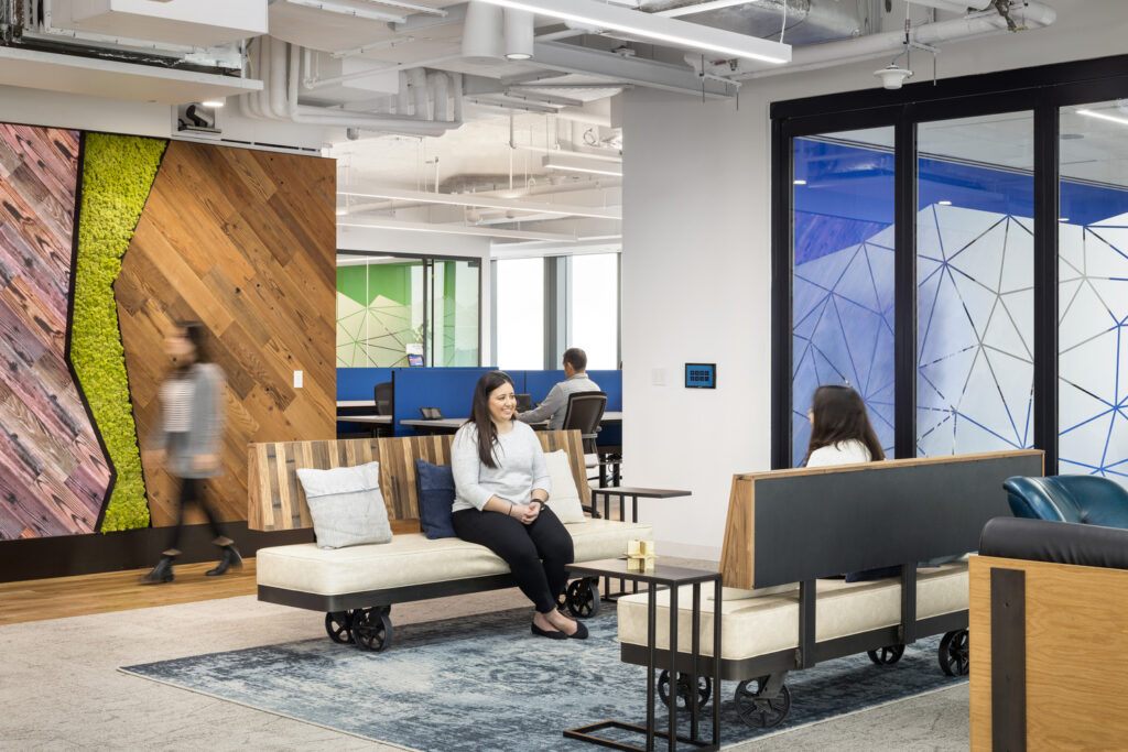 Interior of contemporary office with sustainability and biophilic design, including recycled furniture and moss walls.