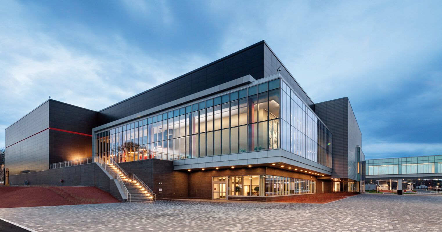 Modern cultural center building illuminated at dusk, showcasing contemporary architecture with a spacious plaza.