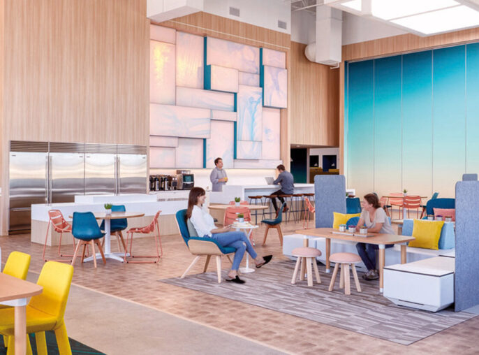 Bright and contemporary open-concept workspace featuring a mix of casual and formal seating arrangements, vibrant color pops on furniture, natural wood paneling, and a striking blue glass partition, creating a dynamic and inviting environment for collaboration and productivity.