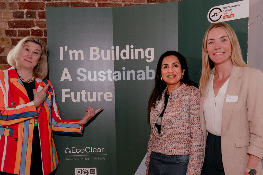 Photo of three people posing in front of a board that says 'I'm building a sustainable future' from the the 2025 Sustainable Design Forum hosted by the Sustainable Design Collective.